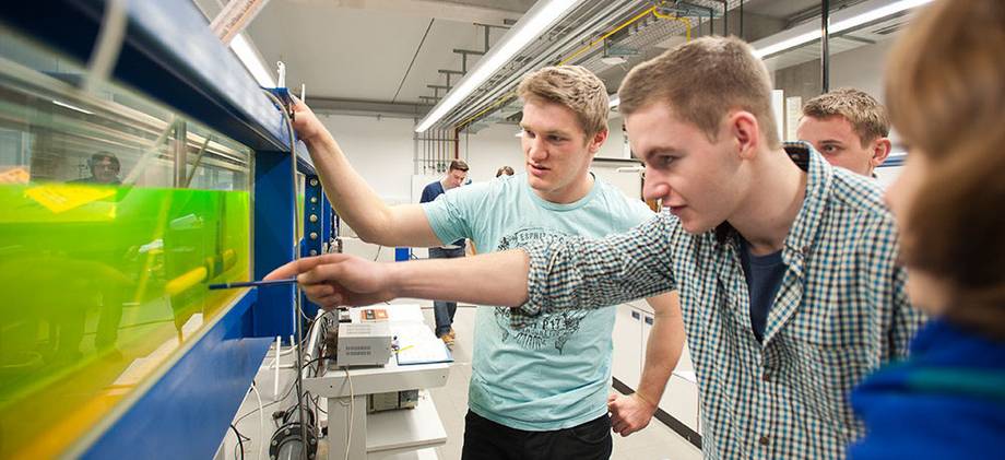 Strömungsversuche im Bauingenieurstudium Studierende vor einer Apparatur zu Strömungsversuchen im Bauingenieurstudium