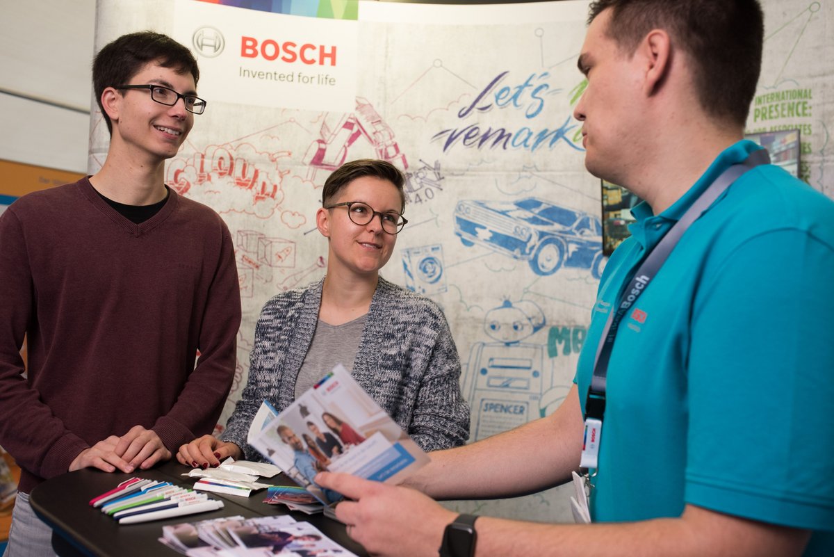 Besucher*innen und Aussteller der campus-X-change stehen im Gespräch am Messestand.