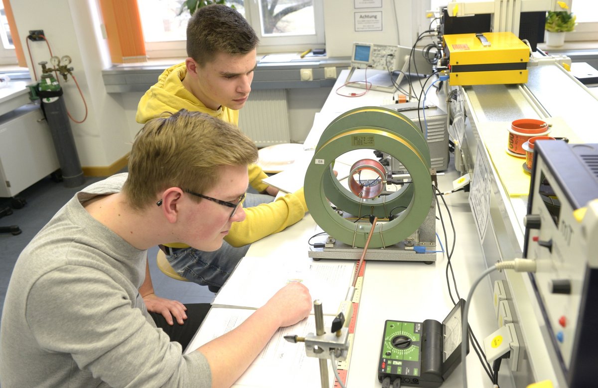 Im Labor sitzend, führen Schüler einen Versuch zur Magnetischen Induktion durch.