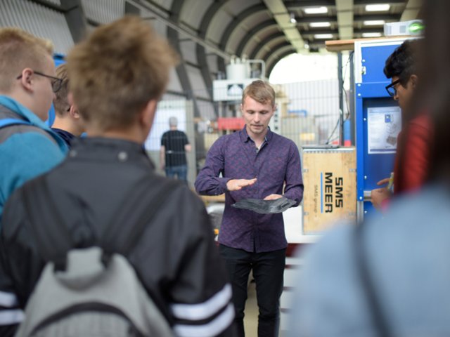 ein BTU-Wissenschaftler erklärt Schüler*innen die ergonomische Weiterentwicklung eines Fahrradsattels 