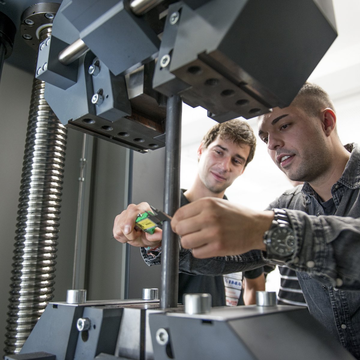 zwei Studierende an der Zug-/Druckmaschine