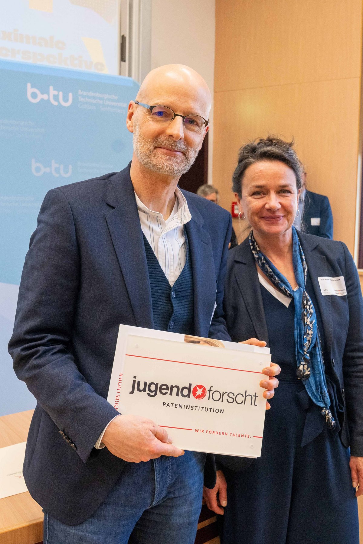 BTU-Vizepräsident Prof. Dr. Peer Schmidt steht neben der Netzwerkkoordinatorin der Stiftung Jugend forscht e.V. Christine Stahlschmidt, die ihm die Jugend forscht Plakette für dei BTU überreicht hat.