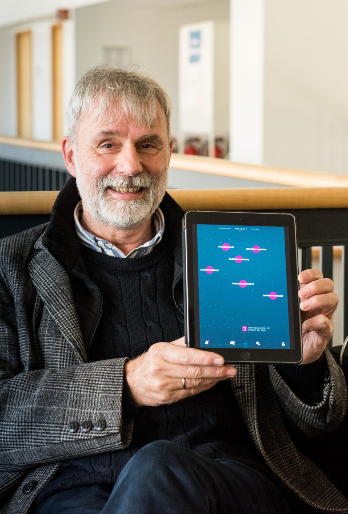 Prof. Dr. Matthias Koziol, wissenschaftlicher Leiter des BTU-Colleges, hält ein Tablet mit der Benutzeroberfäche der Online-Plattform „EDUpilot“ in den Händen.