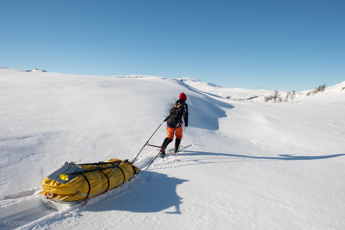 Frau zieht Schlitten durch den Schnee