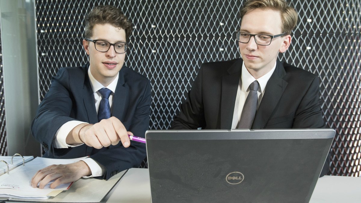 Zwei Kollegen besprechen sich zu den Themen Erfindungen, Patente und Schutzrechte. Die Recherche erfolgt am Notebook. 