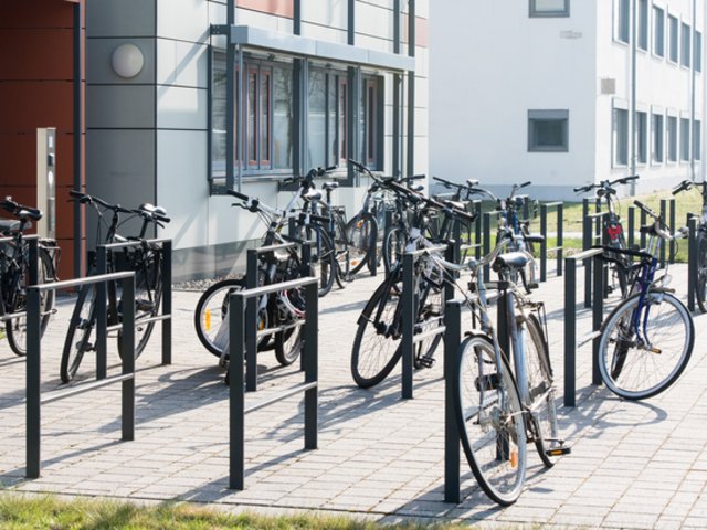 Fahrräder an Fahrradständern vor Gebäude