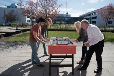 Betriebliche Gesundheitsförderung Kickerspieler auf dem Campus