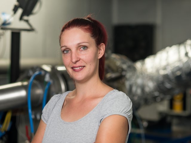 Portraitfoto von Peggy Winkler vor der Mikrogasturbine der Firma B + K