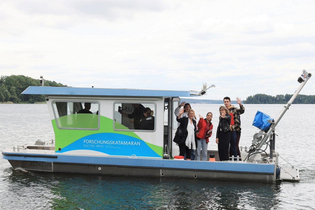 Students wave from the BTU research catamaran.