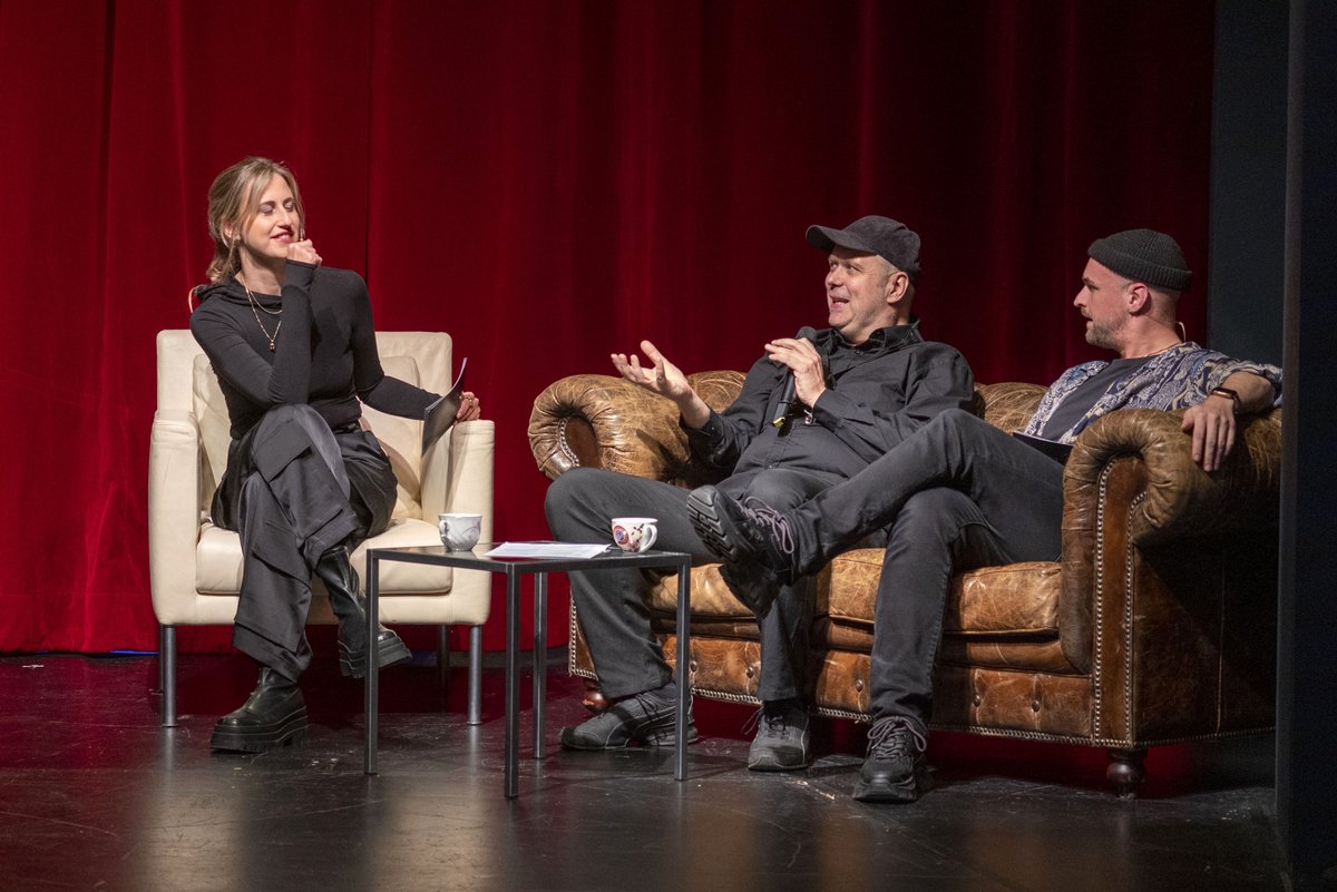 Interview situation: Three people discussing on a sofa.