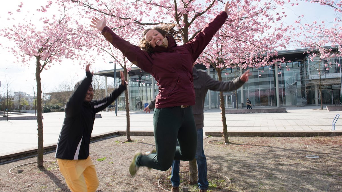 [Translate to Englisch:] Studierende am Zentralcampus springen im Kirschhain in die Lufts