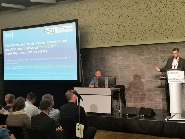 Prof. Dr. Christian Kopkow steht am Rednerpult und hält einen Vortrag auf dem Weltkongress für Physiotherapie. Foto: Dr. Robert Prill