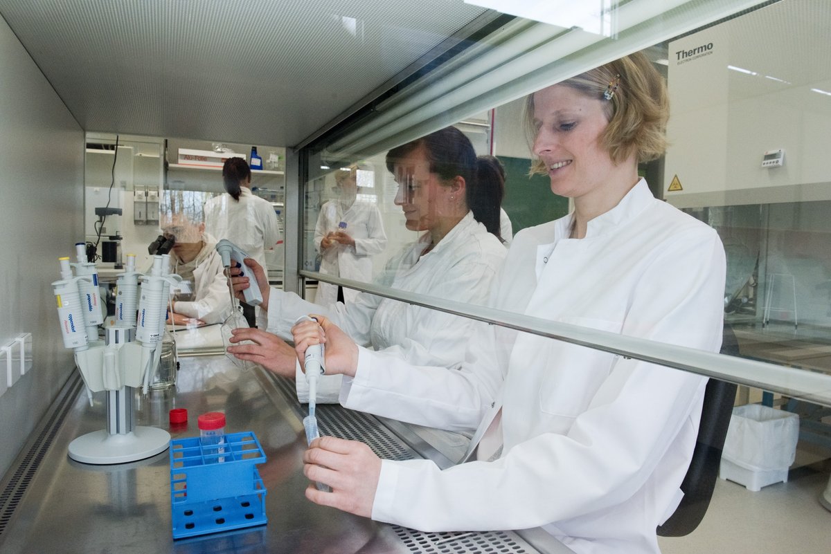 Eine Mitarbeiterin und eine Studentin beim Pipettieren im eienm Biotechnologielabor.