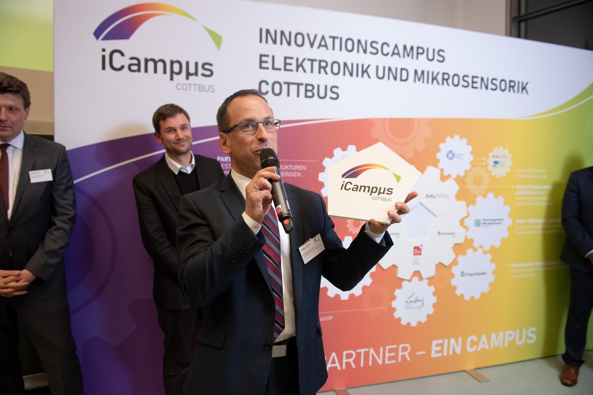 Prof. Harald Schenk mit dem Puzzleteil des iCampus in der Handrs