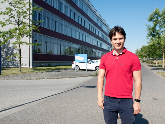 Nelson Barbosa steht an einem sonnigen Tag vor Gebäude 4 auf dem Zentralcampus