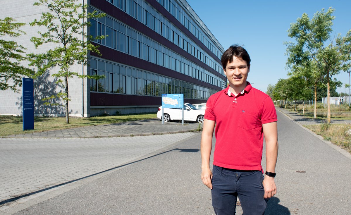 Nelson Barbosa steht an einem sonnigen Tag vor Gebäude 4 auf dem Zentralcampus