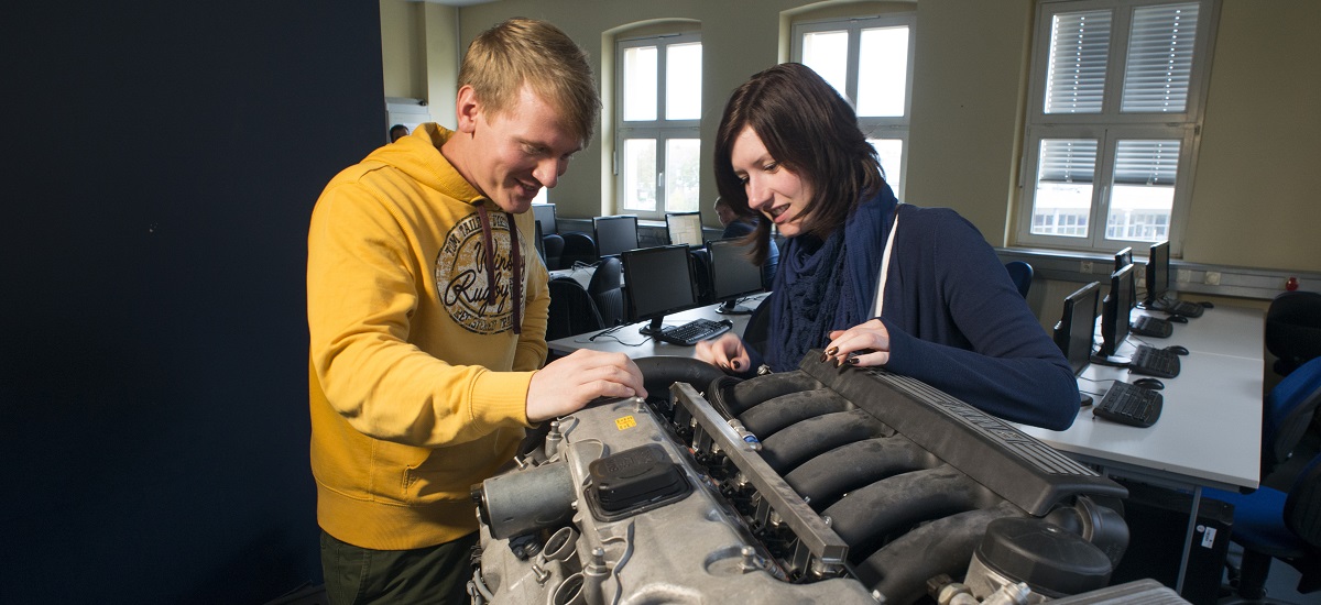 Labor des Modules Qualitätssicherung, Studierende an einem Motor