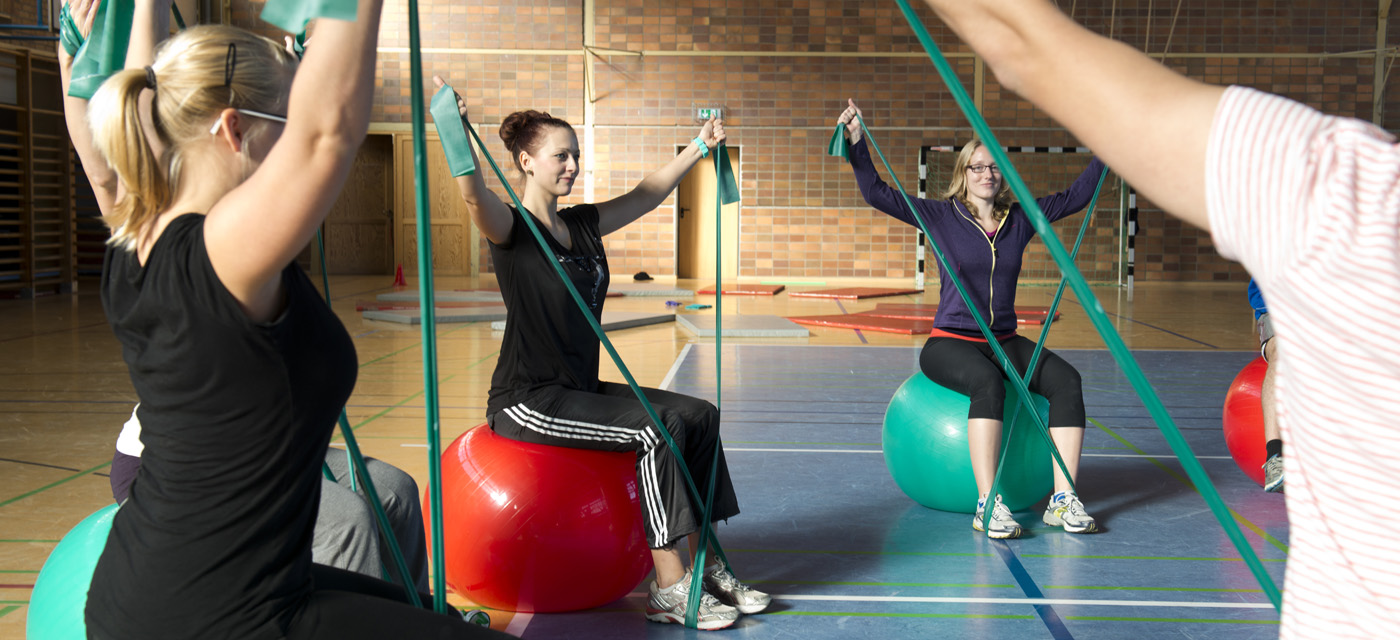 Studierende im Studiengang Therapiewissenschaften bei Gymnastikübungen in der Sporthalle