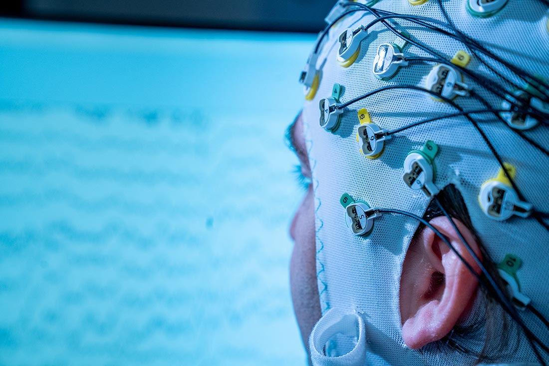 Proband mit EEG-Haube auf dem Kopf