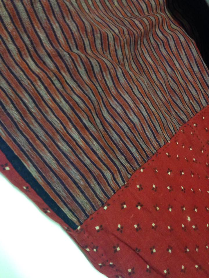 red weaved fabric with a striped pattern on the upper part and an ornamental pattern on the lower part