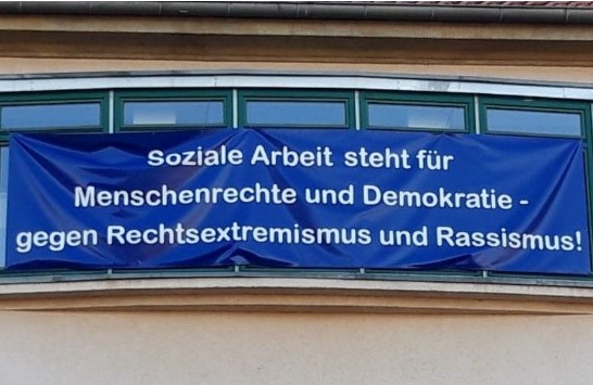 Blaues Banner mit Statement: "Soziale Arbeit steht für Menschenrechte und Demokratie - gegen Rechtsextremismus und Rassismus