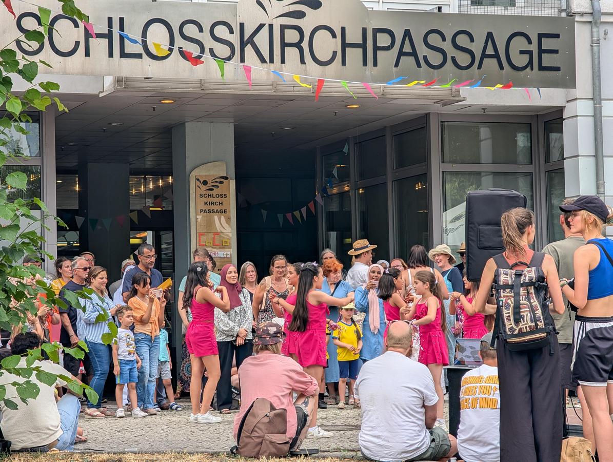 bunte Gruppe Cottbuser vor dem Eingang Schlosskirchpassage