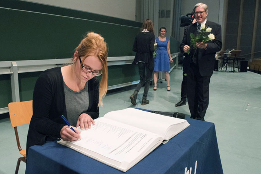 Eine Studentin trägt sich in das Immatrikulationsbuch der BTU ein.