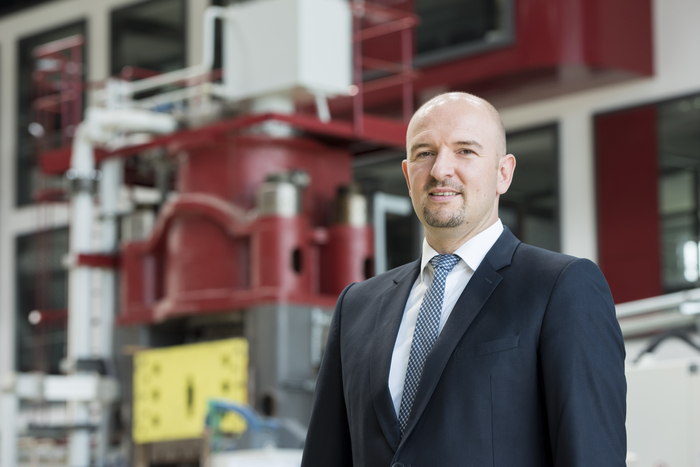 Prof. Markus Bambach vor einer Presse in der Halle des Panta Rhei Zentrums für Leichtbauforschung