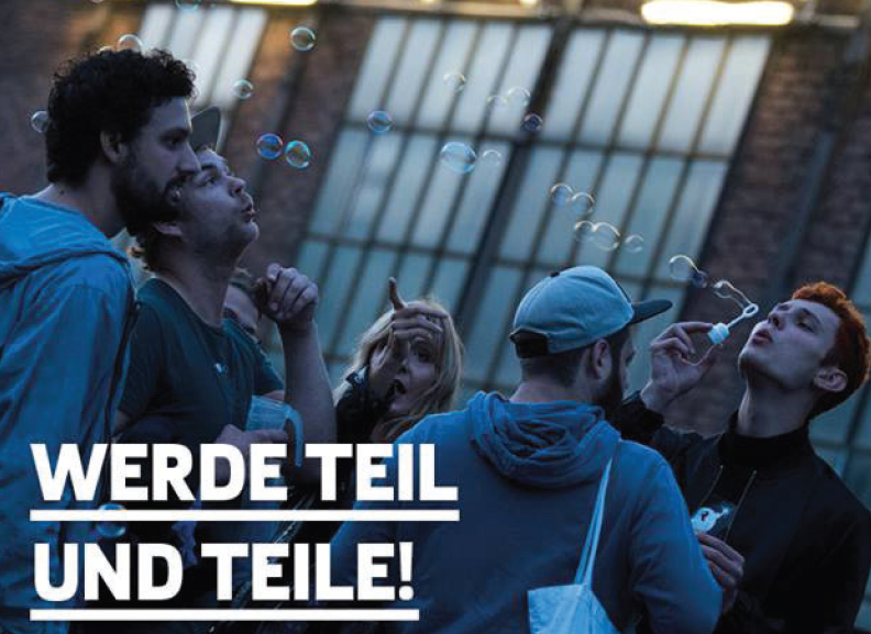 Junge Menschen mit Seifenblasen vor einem Fabrikgelände
