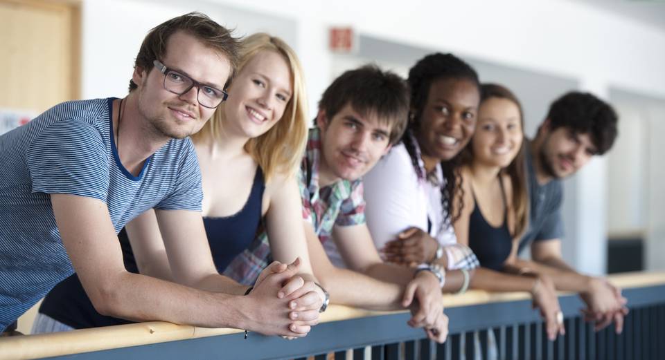 Internationale Studierende am Geländer im Hauptgebäude