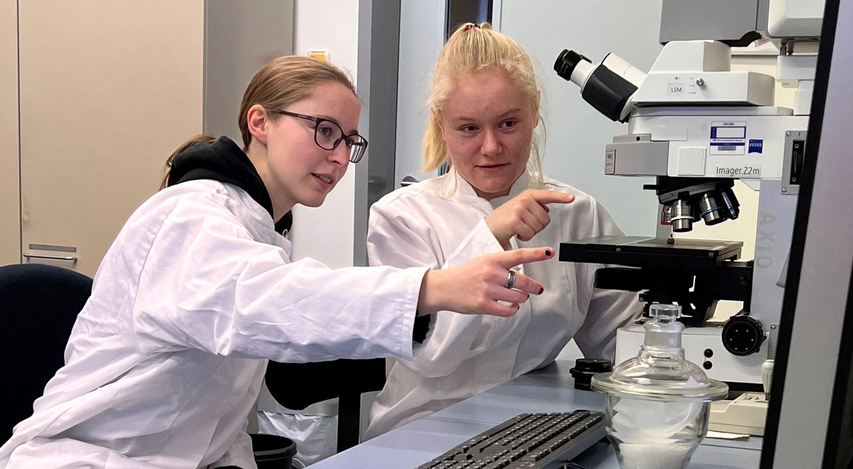 Die MINT-Frauen-Stipendiatinnen Ronja Tittel (links) und Nele Hoffmann an einem Mikroskop im Labor.