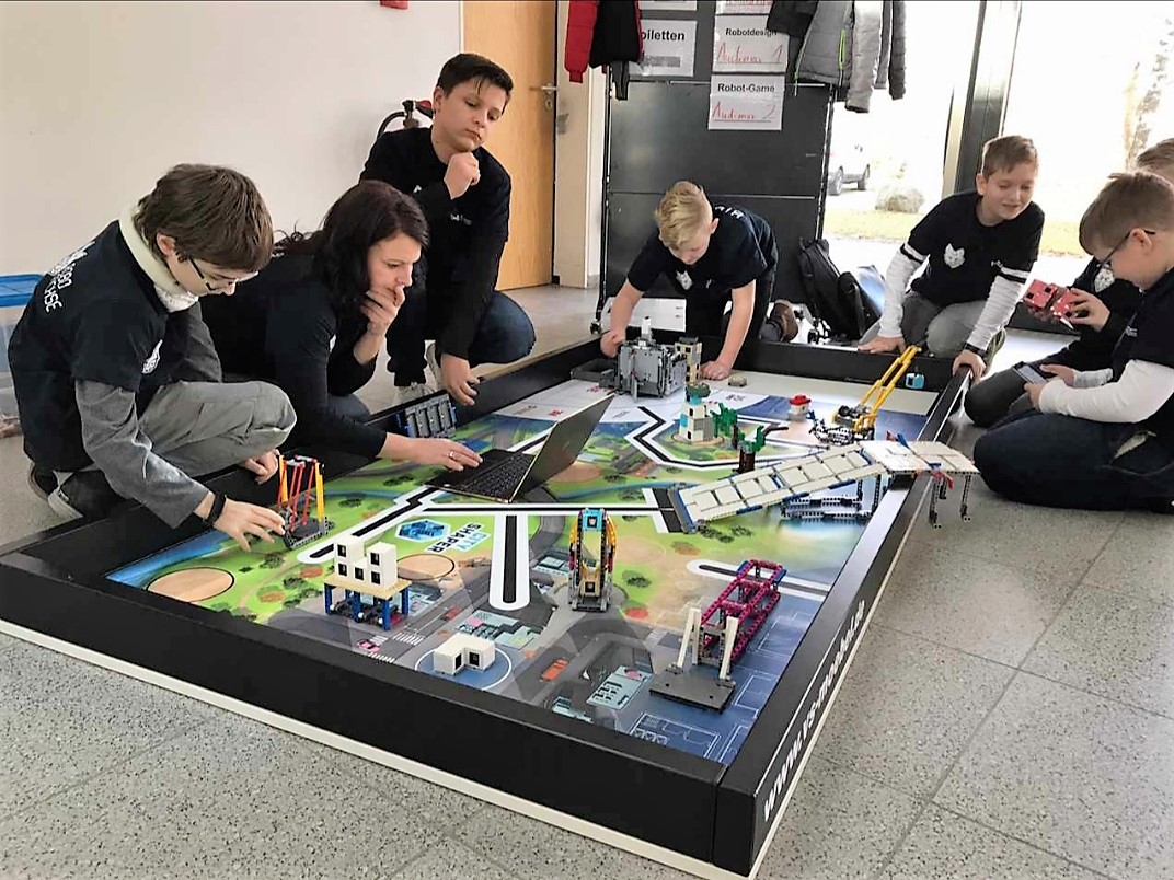 Das BTU-Team "RoboFüchse" mit seinen Roboter am FLL-Spielfeld.ewerb vor.ng auf den Wettbewerb am FLL-Spielfeld. 