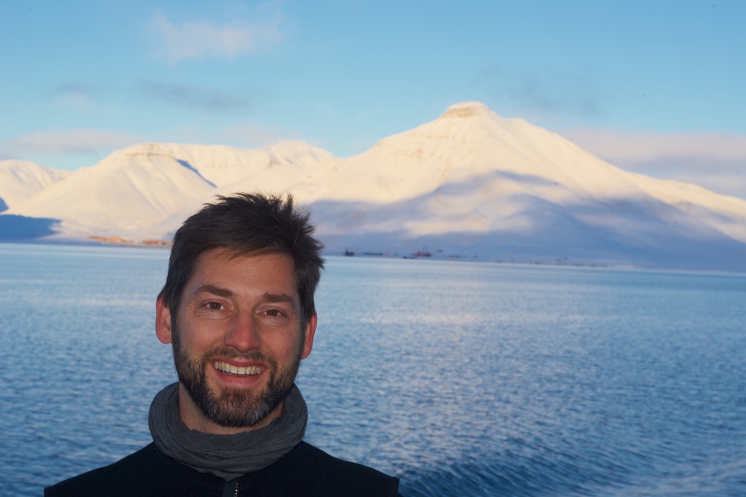 Dr. Felix Christopher Mark vor dem Hintergrund polarer Berge am Meer. Foto: privat