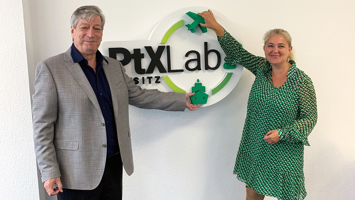 Corinna Enders und Harry Lehmann vor dem Logo des PtX Lab