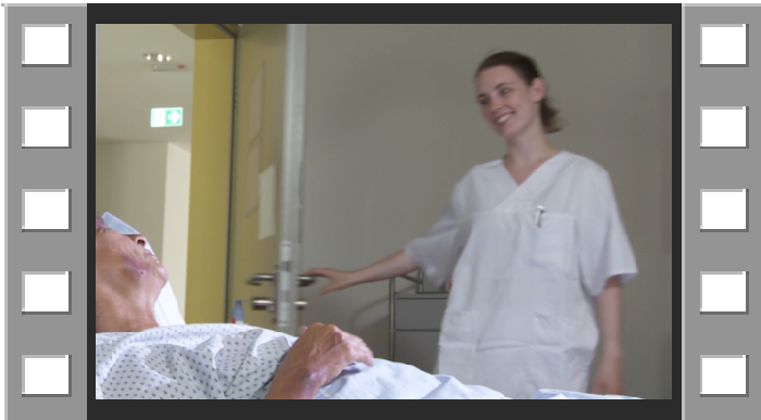 Auf dem Bild ist der Startbildschrim des Videos zur Freiheitsberaubung zu sehen. Sie sehen ist eine ältere Patientin im Pflegebett und eine junge Pflegefachfrau, die das Gespräch eröffnet. 