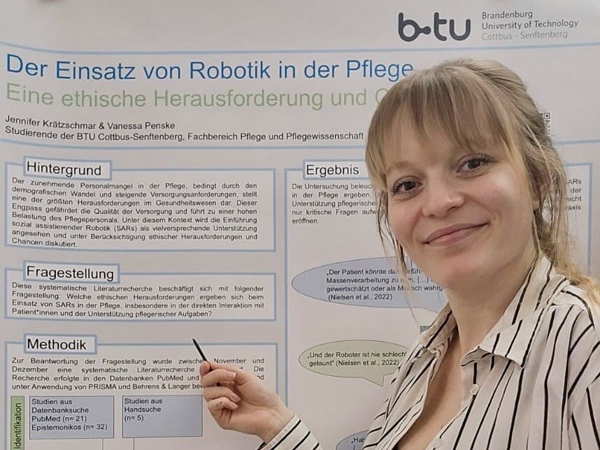Das Foto zeigt Jennifer Krätzschmar mit dem Poster „Der Einsatz von Robotik in der Pflege - Eine ethische Herausforderung und Chance“