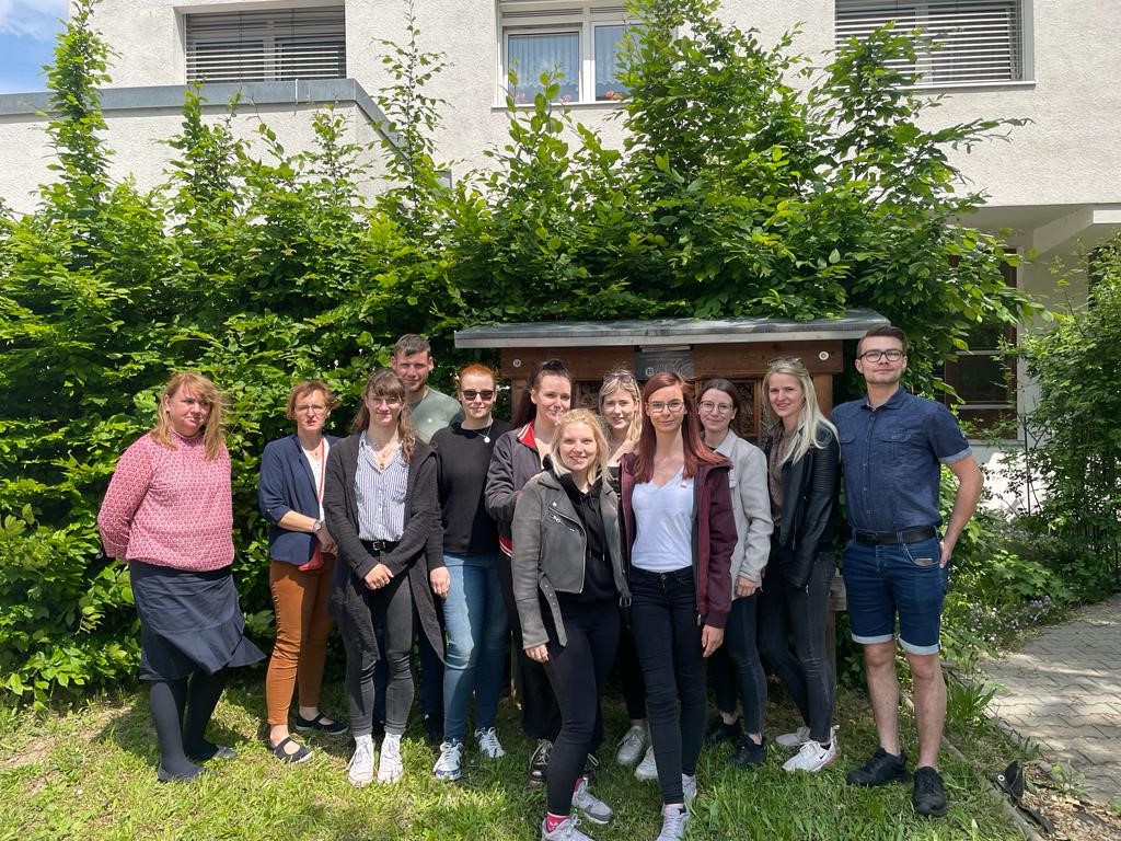 Das Foto zeigt ein Gruppenbild mit den Dozentinnen Jeannette Jänchen (1.v.r.) sowie Peggy Simmank (2.v.r.) und Studierenden des 4. / 8. SE vor einem Gebäude