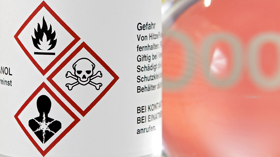 drei Gefahrensymbole auf einer Glasflasche